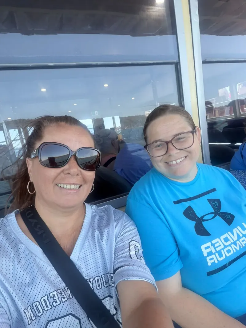 Two friends smiling for a selfie on a Sydney ferry outing