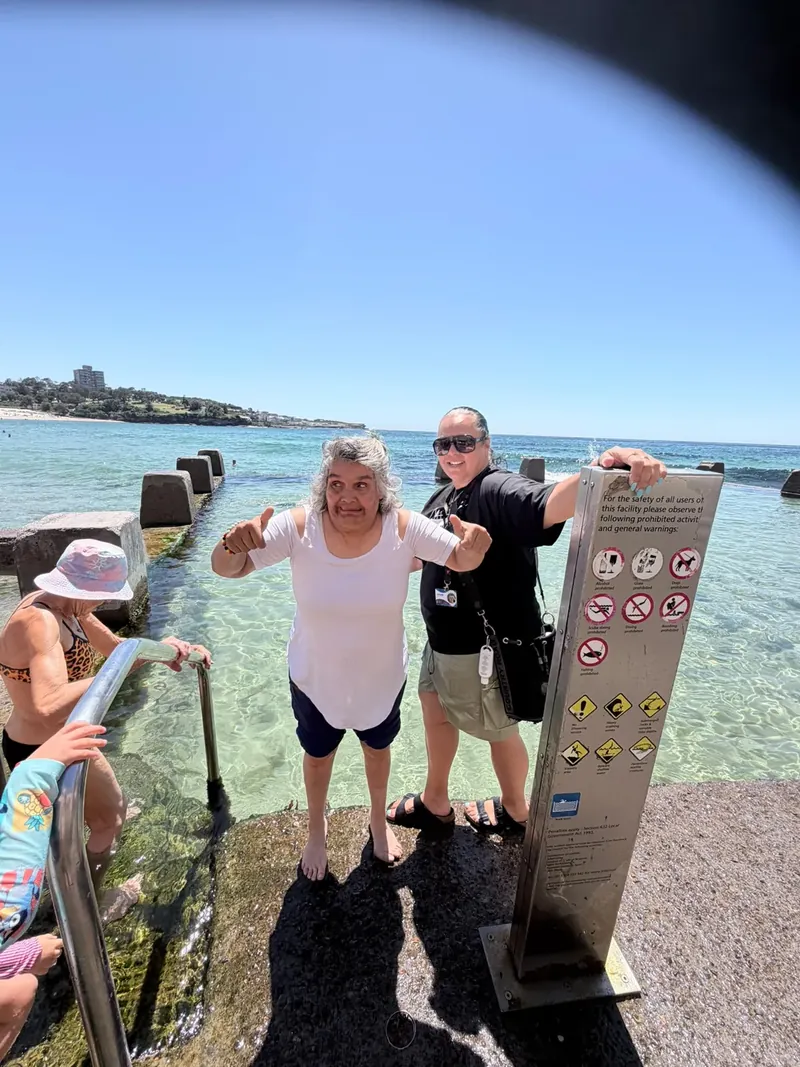 A participant giving a thumbs up beside a Sydney ocean pool