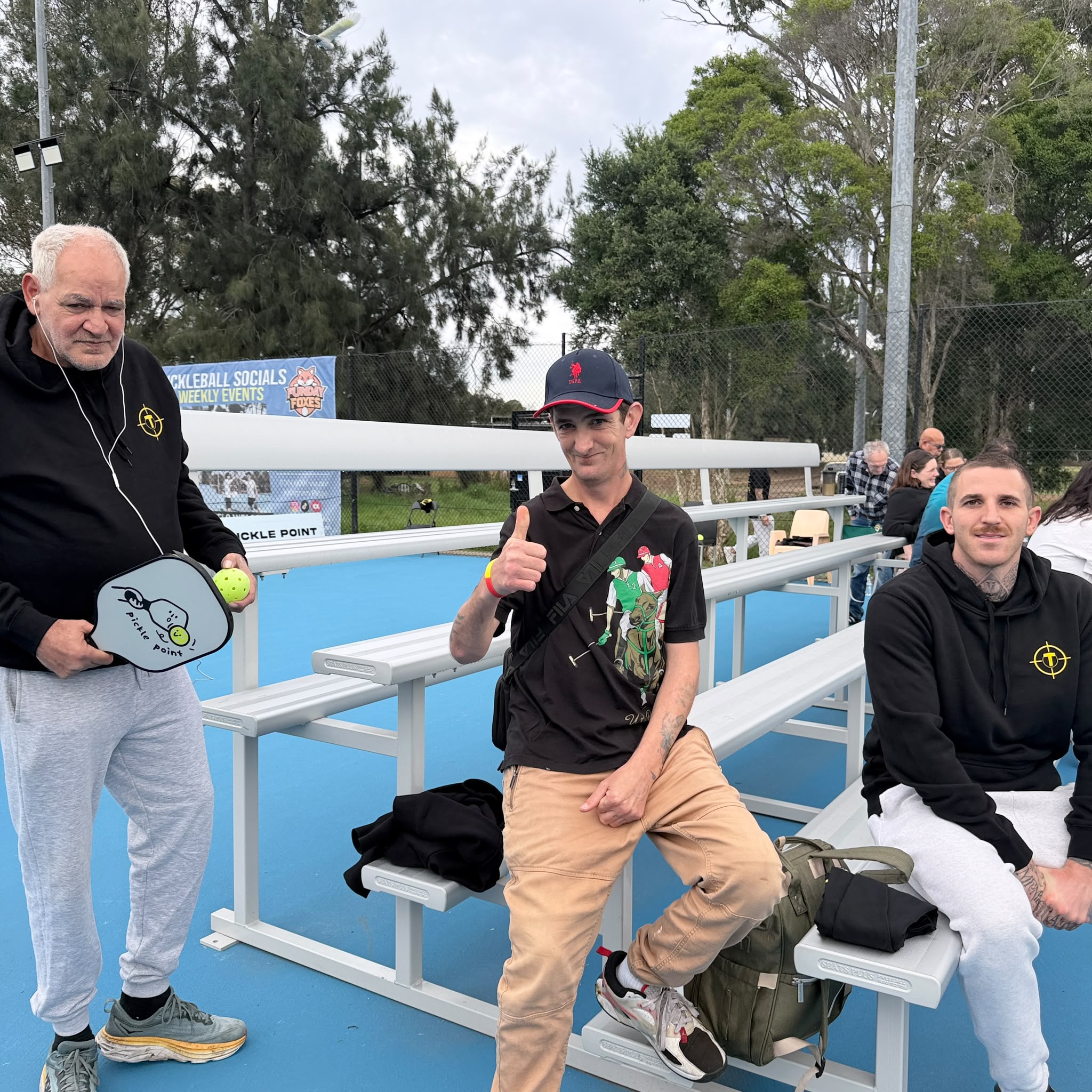 Tegrity participants and support workers relaxing courtside at the pickleball day