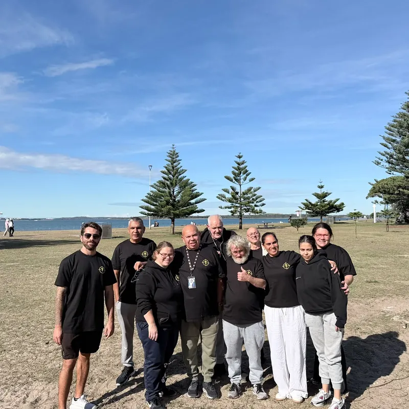 The Tegrity team in branded shirts together on the grass by the coast